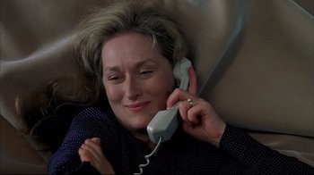 Movie still from “Adaptation.” (2002), directed by Spike Jonze – An older woman talking on a phone while laying on a couch; Close Up shot, Overhead angle