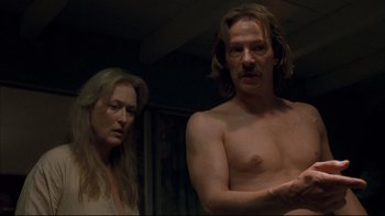 Movie still from “Adaptation.” (2002), directed by Spike Jonze – A man and a woman standing next to each other in a room; Medium shot, Over the shoulder angle