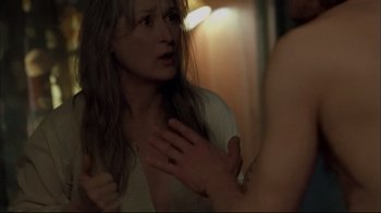 Movie still from “Adaptation.” (2002), directed by Spike Jonze – A young woman looking into a mirror with her hands on her chest; Close Up shot, Over the shoulder angle