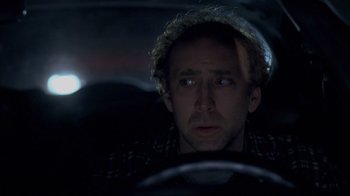 Movie still from “Adaptation.” (2002), directed by Spike Jonze – A man in a hat driving a car at night; Close Up shot, Over the shoulder angle