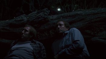 Movie still from “Adaptation.” (2002), directed by Spike Jonze – A couple of men standing next to each other in the dark; Medium shot, Low angle