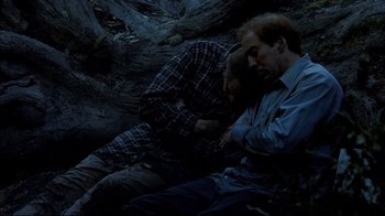 Movie still from “Adaptation.” (2002), directed by Spike Jonze – Two men are sleeping on the ground in the dark; Medium shot, Low angle