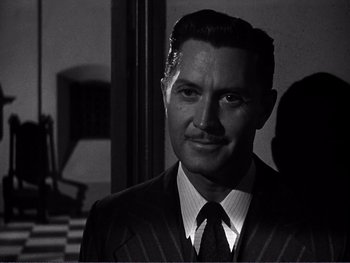 Movie still from “Address Unknown” (1944), directed by William Cameron Menzies – A black and white photo of a man in a suit and tie; Close Up shot, Over the shoulder angle