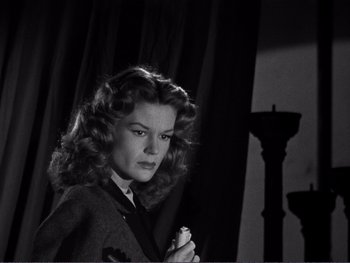 Movie still from “Address Unknown” (1944), directed by William Cameron Menzies – A black - and - white photo of a woman holding a candle; Close Up shot, Low angle