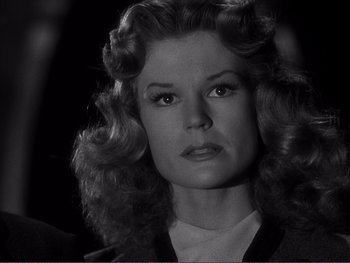 Movie still from “Address Unknown” (1944), directed by William Cameron Menzies – A black and white photo of a woman with curly hair; Close Up shot, Low angle