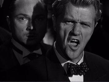 Movie still from “Address Unknown” (1944), directed by William Cameron Menzies – A man in a suit and a bow tie; Close Up shot, Low angle