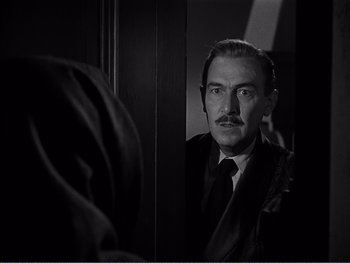 Movie still from “Address Unknown” (1944), directed by William Cameron Menzies – A black and white photo of a man looking at himself in the mirror; Close Up shot, Over the shoulder angle