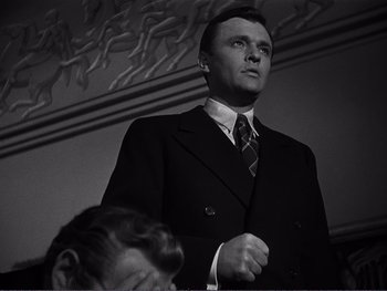 Movie still from “Address Unknown” (1944), directed by William Cameron Menzies – A black and white photo of a man in a suit and tie; Close Up shot, Low angle