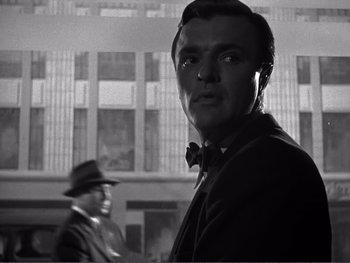 Movie still from “Address Unknown” (1944), directed by William Cameron Menzies – A black and white photo of a man in a suit and bow tie; Close Up shot, Low angle