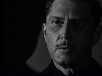 Movie still from “Address Unknown” (1944), directed by William Cameron Menzies – Black and white photograph of a man with a mustache; Close Up shot, Over the shoulder angle