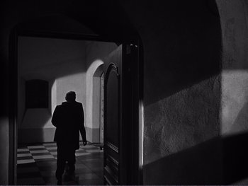 Movie still from “Address Unknown” (1944), directed by William Cameron Menzies – A person standing in a room with a door open; Wide shot, Low angle
