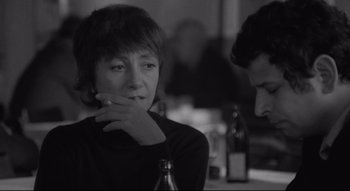 A woman sitting next to a man in a bar