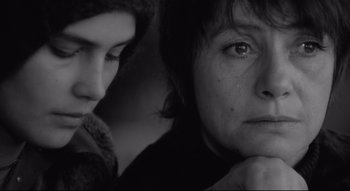 A woman sitting next to another woman with her hand on her chin