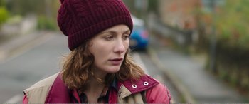 Movie still from “Adult Life Skills” (2016), directed by Rachel Tunnard – A person wearing a jacket and a hat; Close Up shot, Over the shoulder angle
