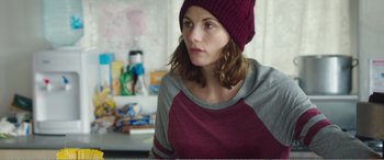 Movie still from “Adult Life Skills” (2016), directed by Rachel Tunnard – A woman wearing a red hat looking to her left; Medium shot, Over the shoulder angle