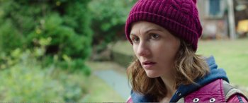 Movie still from “Adult Life Skills” (2016), directed by Rachel Tunnard – A person wearing a hat near a tree; Close Up shot, Over the shoulder angle
