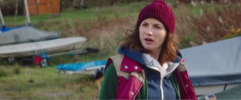 Movie still from “Adult Life Skills” (2016), directed by Rachel Tunnard – A woman wearing a red hat and a blue jacket; Close Up shot, Over the shoulder angle