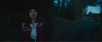 Movie still from “Adult Life Skills” (2016), directed by Rachel Tunnard – A woman standing in the dark near a forest; Close Up shot, Low angle