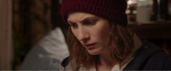 Movie still from “Adult Life Skills” (2016), directed by Rachel Tunnard – A person wearing a hat; Close Up shot, Over the shoulder angle