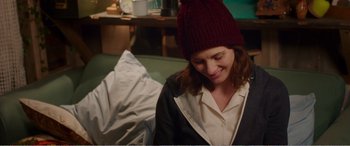 Movie still from “Adult Life Skills” (2016), directed by Rachel Tunnard – A woman wearing a hat sitting on a couch; Medium shot, Over the shoulder angle