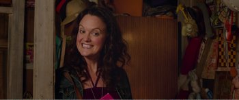 Movie still from “Adult Life Skills” (2016), directed by Rachel Tunnard – A woman with long curly brown hair smiling for the camera; Close Up shot, Over the shoulder angle