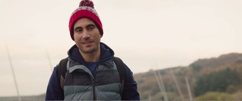 Movie still from “Adult Life Skills” (2016), directed by Rachel Tunnard – A man wearing a red hat and a black jacket; Close Up shot, Low angle