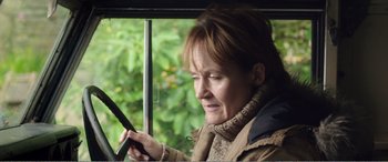 Movie still from “Adult Life Skills” (2016), directed by Rachel Tunnard – A woman looking at her cell phone while riding a bus; Close Up shot, Low angle