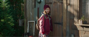 Movie still from “Adult Life Skills” (2016), directed by Rachel Tunnard – A young girl wearing a red jacket and a red hat; Medium shot, Over the shoulder angle