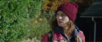 Movie still from “Adult Life Skills” (2016), directed by Rachel Tunnard – A woman wearing a red hat and a red jacket; Close Up shot, Over the shoulder angle