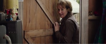 Movie still from “Adult Life Skills” (2016), directed by Rachel Tunnard – A woman leaning against a wooden door; Close Up shot, Over the shoulder angle