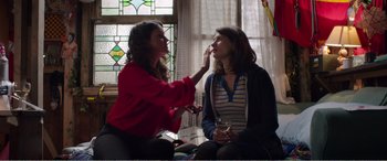 Movie still from “Adult Life Skills” (2016), directed by Rachel Tunnard – A woman is putting makeup on another woman's face; Medium shot, Over the shoulder angle