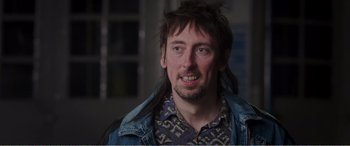 Movie still from “Adult Life Skills” (2016), directed by Rachel Tunnard – A person wearing a jean jacket; Close Up shot, Over the shoulder angle