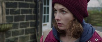Movie still from “Adult Life Skills” (2016), directed by Rachel Tunnard – A person wearing a jacket and a hat; Close Up shot, Over the shoulder angle