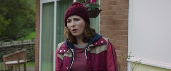 Movie still from “Adult Life Skills” (2016), directed by Rachel Tunnard – A woman wearing a red jacket and a red hat; Medium shot, Over the shoulder angle