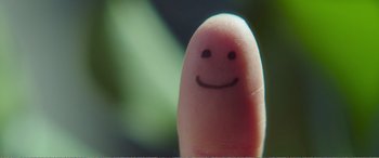 Movie still from “Adult Life Skills” (2016), directed by Rachel Tunnard – A finger with a smile drawn on it; Extreme Close Up shot, High angle