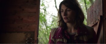 Movie still from “Adult Life Skills” (2016), directed by Rachel Tunnard – A woman standing in front of a window with trees in the background; Close Up shot, Over the shoulder angle