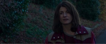 Movie still from “Adult Life Skills” (2016), directed by Rachel Tunnard – A woman with long brown hair wearing a red shirt; Close Up shot, Over the shoulder angle