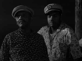 Movie still from “Affair in Trinidad” (1952), directed by Vincent Sherman – A couple of men standing next to each other; Medium shot, Low angle