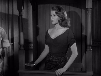 Movie still from “Affair in Trinidad” (1952), directed by Vincent Sherman – A black and white photo of a woman in a black dress; Medium shot, Low angle