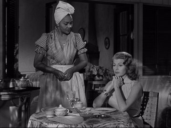 Movie still from “Affair in Trinidad” (1952), directed by Vincent Sherman – Two women sitting at a table in front of a table; Medium shot, Over the shoulder angle