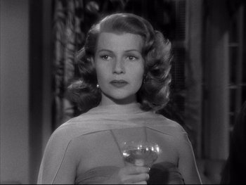 Movie still from “Affair in Trinidad” (1952), directed by Vincent Sherman – A black and white photo of a woman holding a wine glass; Close Up shot, Low angle
