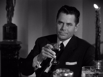 Movie still from “Affair in Trinidad” (1952), directed by Vincent Sherman – A black and white photo of a man holding a wine glass; Close Up shot, Over the shoulder angle