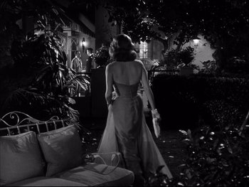 Movie still from “Affair in Trinidad” (1952), directed by Vincent Sherman – A black and white photo of a woman in a dress; Wide shot, Low angle