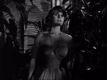 Movie still from “Affair in Trinidad” (1952), directed by Vincent Sherman – A black and white photo of a woman in a dress; Medium shot, Low angle