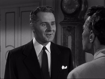 Movie still from “Affair in Trinidad” (1952), directed by Vincent Sherman – A man in a suit and tie talking to another man in a suit and tie; Close Up shot, Over the shoulder angle
