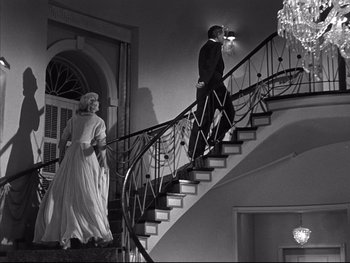 Movie still from “Affair in Trinidad” (1952), directed by Vincent Sherman – A man and a woman walking down a staircase; Wide shot, Low angle