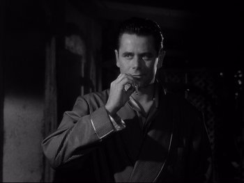 Movie still from “Affair in Trinidad” (1952), directed by Vincent Sherman – A black and white photo of a man talking on a phone; Close Up shot, Low angle