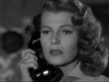 Movie still from “Affair in Trinidad” (1952), directed by Vincent Sherman – A woman holding a phone up to her ear; Close Up shot, Low angle