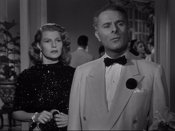 Movie still from “Affair in Trinidad” (1952), directed by Vincent Sherman – A man and a woman standing next to each other; Medium shot, Low angle