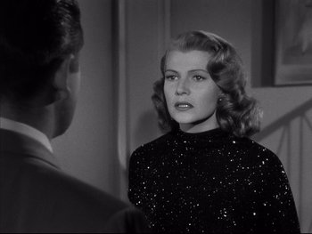 Movie still from “Affair in Trinidad” (1952), directed by Vincent Sherman – A black and white photo of a woman in a black dress; Close Up shot, Over the shoulder angle